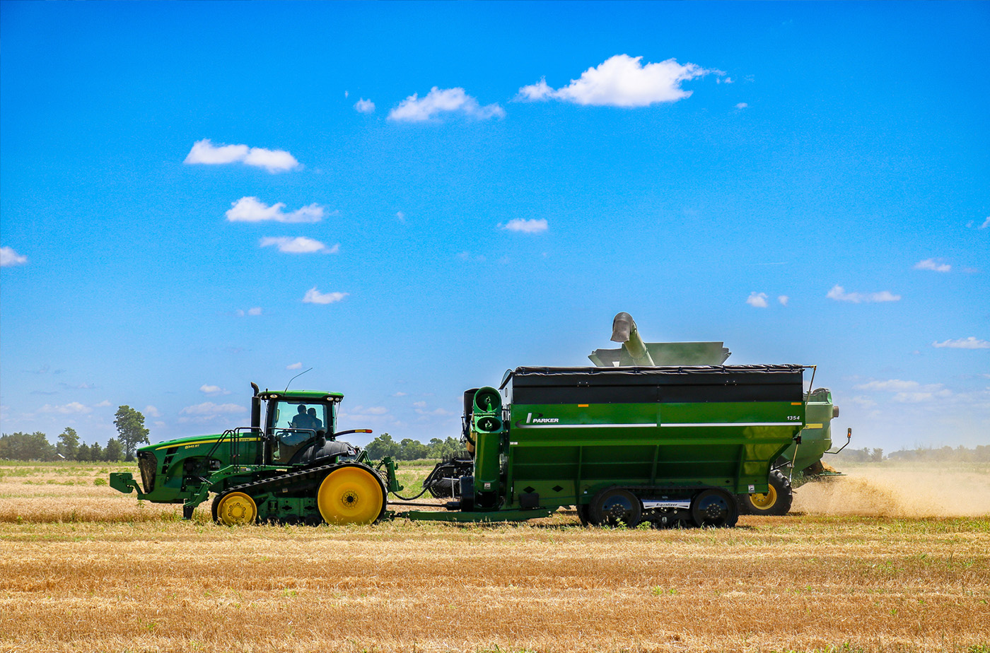 Agricultural vehicle at work in field with trackman tracks